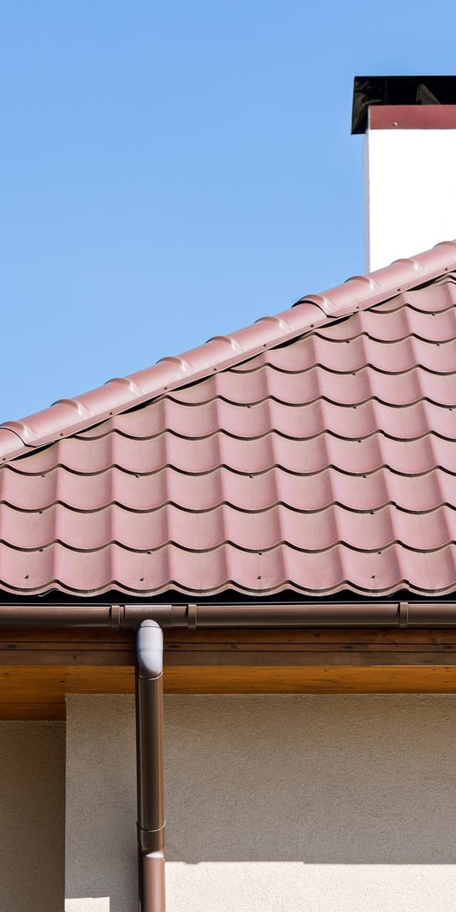 Corner of a house with gutter and tiled roof